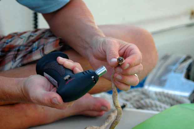 Burning the ends with a creme brûlée torch.  Great tool to have on a boat!